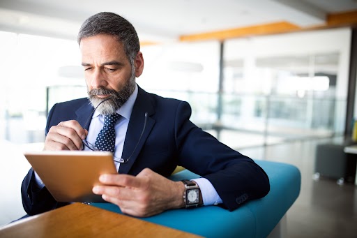 Portrait of handsome senior businessman with digital tablet in office